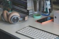 laptop, sluchawki, telefon, ksiażki na biurku